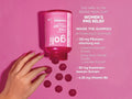 Pink bottle labeled 'GOJI' with gummies on a pink background