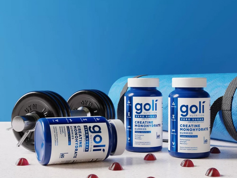 Goli supplement bottles with gym equipment on a blue background