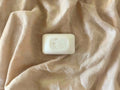 Bar of soap with 'Hope for Relief' branding on a beige fabric background