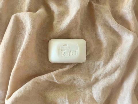 Bar of soap with 'Hope for Relief' branding on a beige fabric background