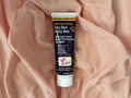 Tube of Derma-Lotion for dry skin and itchy skin on a pink fabric background