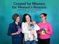 Three women holding products with a teal background and text about women's wellness.