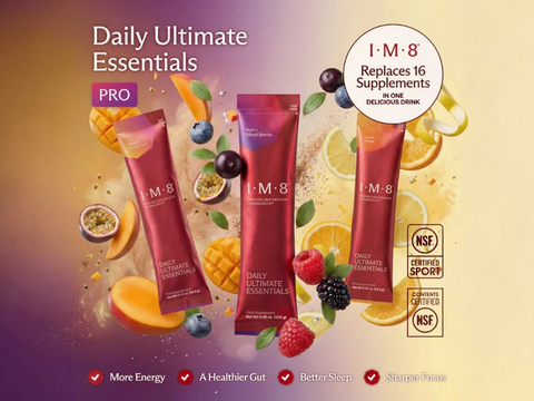 Three tubes of I-M-8 Daily Ultimate Essentials PRO supplement arranged on a colorful gradient background with fruit slices, berries, and lemons. Text highlights 'Daily Ultimate Essentials PRO' and includes NSF Certified Sport and NSF Certified for Good Practices seals.