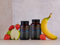 Two bottles of Kiki Health Body Biotics Gummies with fruits on a neutral background