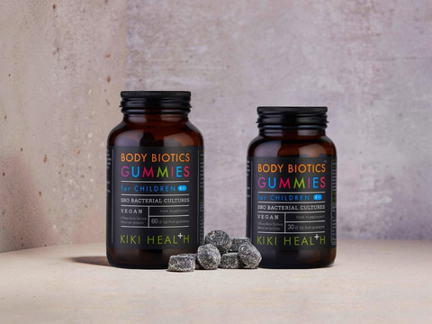 Two bottles of Kiki Health Body Biotics Gummies for children on a neutral background