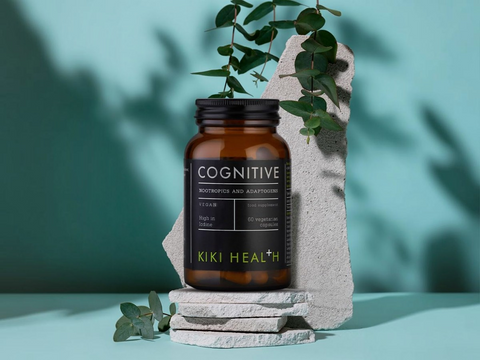 Brown bottle labeled 'Cognitive' by Kiki Health on a stone surface with greenery