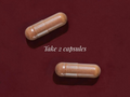 Two capsules on a red background with text 'Take 2 capsules'.