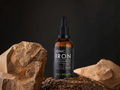 Bottle of Kiki Health Ionic Iron supplement on a dark background with rocks.