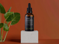 KIKI Health Ionic Magnesium dropper bottle on a white pedestal with a plant against an orange background