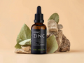 KIKI Health Ionic Zinc liquid concentrate bottle with dropper on a beige background with rocks and leaves.