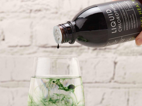 Bottle of Liquid Chlorophyll being poured into a glass with a light background