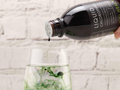 Bottle of Liquid Chlorophyll being poured into a glass with a light background