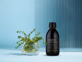 Bottle of KIKI Health Liquid Chlorophyll with a plant on a light blue background