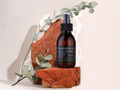 Bottle of magnesium oil spray on a natural stone surface with eucalyptus leaves.