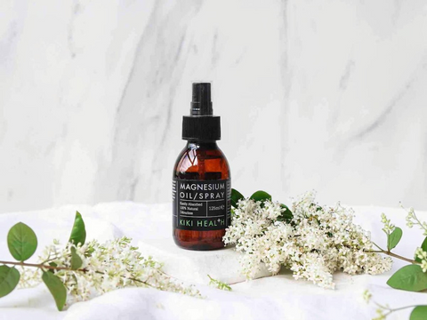 Bottle of magnesium oil spray with flowers on a white background