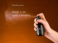 Hand holding a spray bottle with directions for use on a brown background