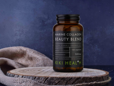 Marine Collagen Beauty Blend supplement bottle by KIKI Health on a wooden surface with a dark background