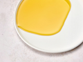 Yellow dessert on a white plate with a light background