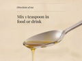 Spoon with honey dripping, text 'Mix 1 teaspoon in food or drink' on a beige background