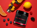 Kaged Pre-Workout supplement container with fruits on a red background