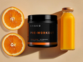 Kaged pre-workout supplement with oranges and a bottle of orange juice on a beige background