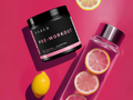 Kaged Pre-Workout supplement jar and pink water bottle with lemon slices on a pink background