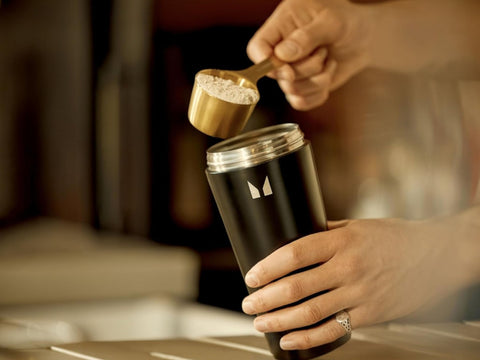 How to Use: MyProtein Vanilla Whey Protein powder being mixed in a shaker bottle.