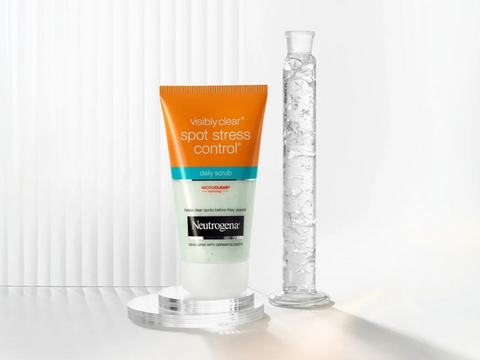 Neutrogena Visibly Clear Daily Scrub 150ml tube, blue and white packaging, isolated on white.