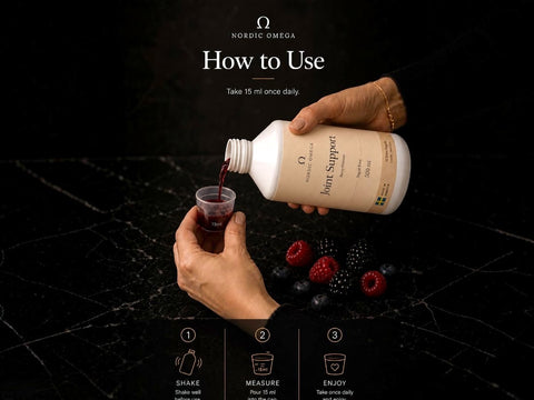 A lifestyle instructional graphic showing hands pouring a dark red liquid from a white bottle labeled 'Nordic Omega Joint Support' into a small cup on a black marble surface, with berries nearby and step-by-step usage icons at the bottom.