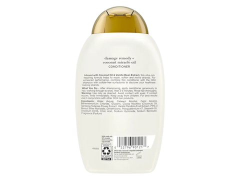 Back view of a bottle of OGX Damage Remedy + Coconut Miracle Oil Conditioner on a white background