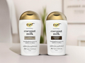 Two bottles of OGX coconut milk shampoo and conditioner on a neutral background