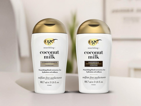 Two bottles of OGX coconut milk shampoo and conditioner on a neutral background