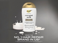 Ouidad coconut milk conditioner bottle with splashes on a gray background