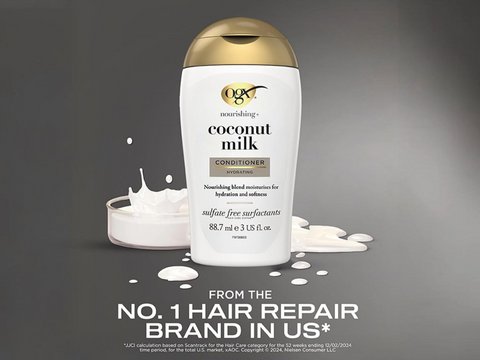 Ouidad coconut milk conditioner bottle with splashes on a gray background