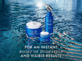 Olay skincare products with water droplet on a blue water background