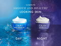 Two Olay skincare products, one labeled 'Day' and one labeled 'Night', on a blue and purple gradient background.