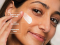 Woman applying skincare product with text highlighting features on a white background