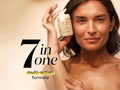 Woman holding an Olay skincare product with '7 in one' text on a beige background