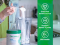 Person adding powder to a blender with Organika product packaging and health benefits text on the side.