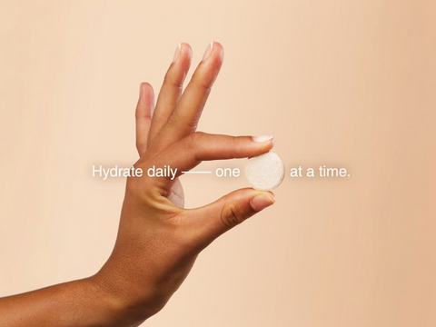 Hand holding a small white object against a beige background with text overlay.