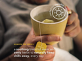 Person holding a yellow mug with a tea bag, featuring text about a soothing blend of herbs.