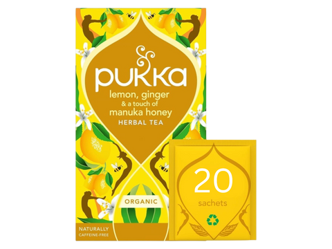 Pukka lemon, ginger, and manuka honey herbal tea packaging on a white background