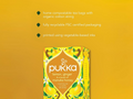 Pukka lemon, ginger, and manuka honey tea packaging on a yellow background with sustainability information.
