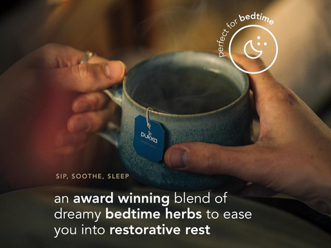 Blue mug held by hands with a tea bag label, text about bedtime herbs, and 'Pukka' branding.