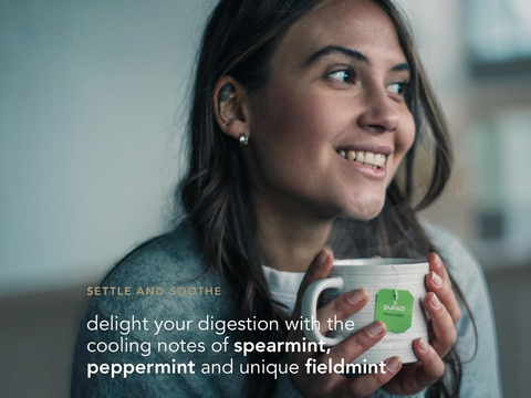 Woman holding a mug with text about digestive benefits