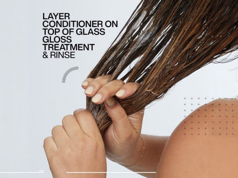 Redken Conditioner being applied to the lengths of wet hair.