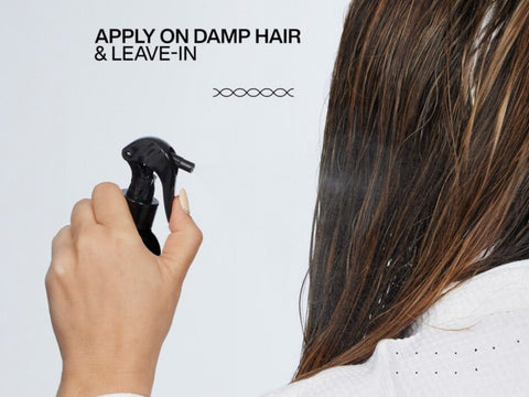 Redken Leave-In Spray being misted onto damp hair.
