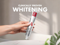 Hand holding a tube of Extreme White toothpaste with 'Clinically Proven Whitening' text.