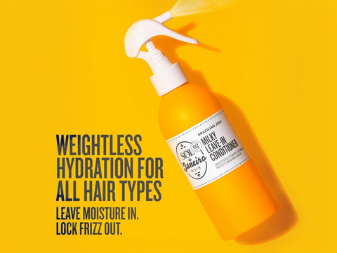 Orange bottle of hair conditioner with a white label on a yellow background