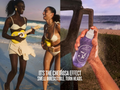Two women playing guitar on a beach with a bottle of sunscreen labeled 'The Cheirosa Effect' held by a hand.